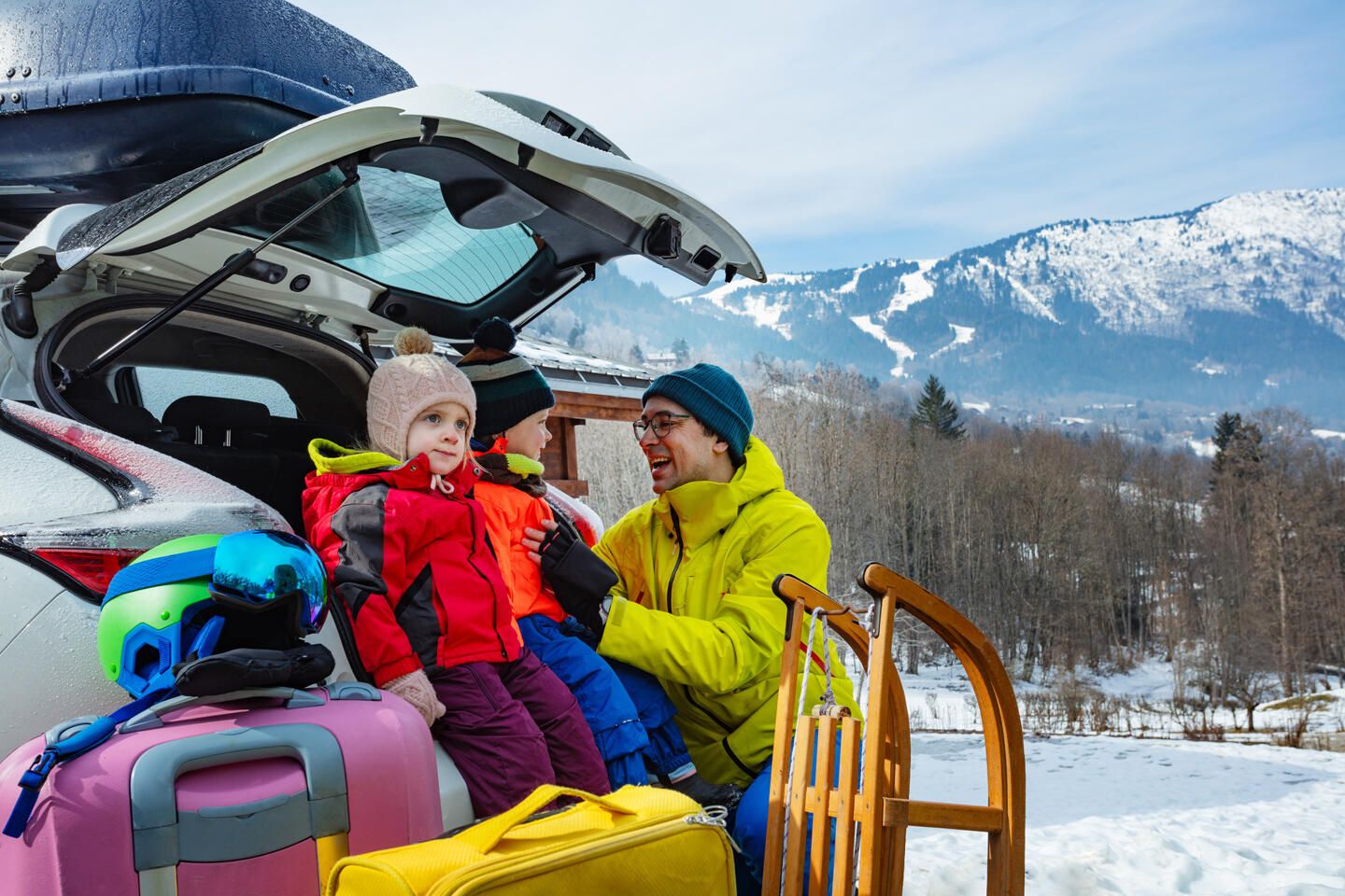 Familie lädt das Auto für eine Reise im Schnee