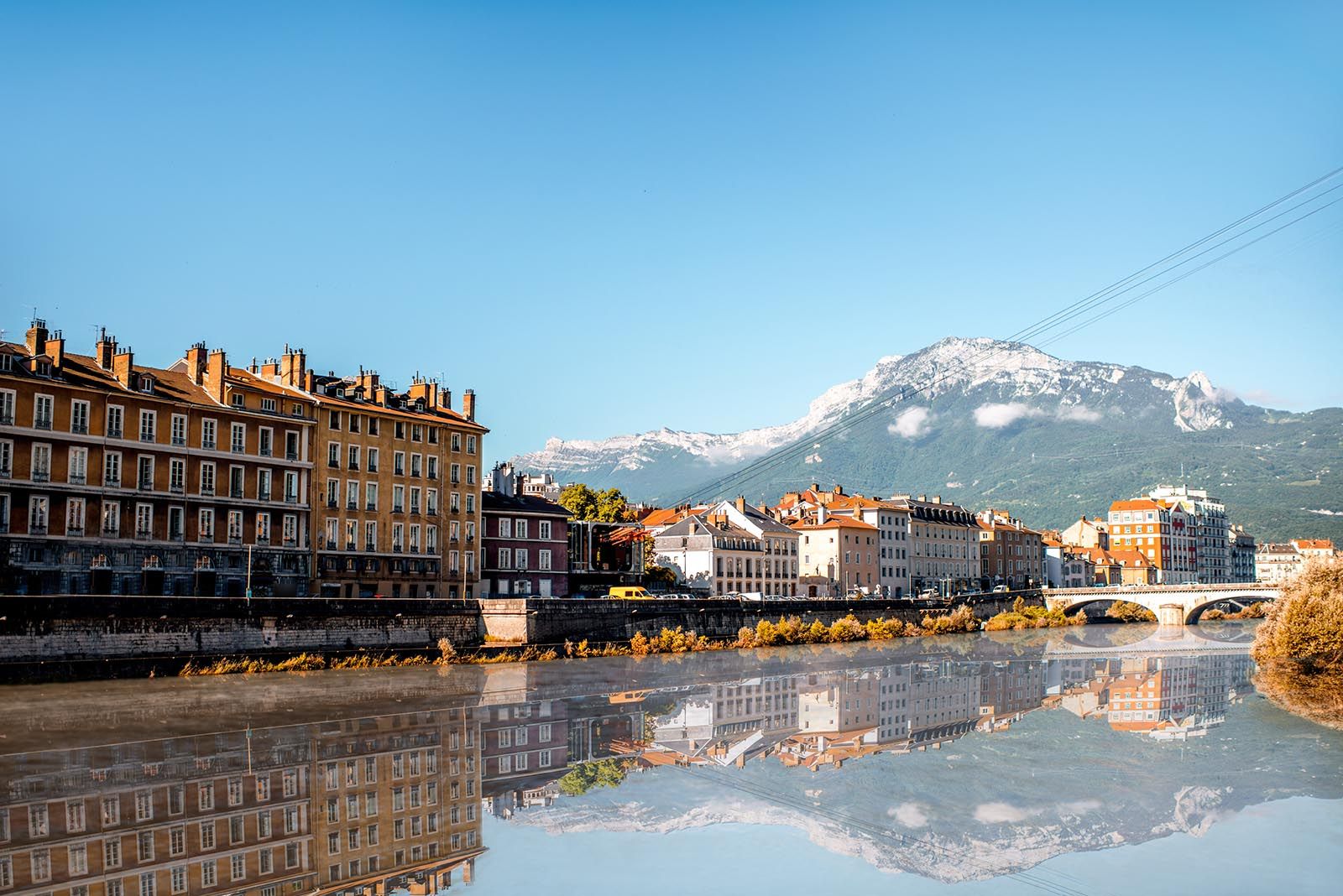 Grenoble avec quais de l’Isère, immeubles et montagnes