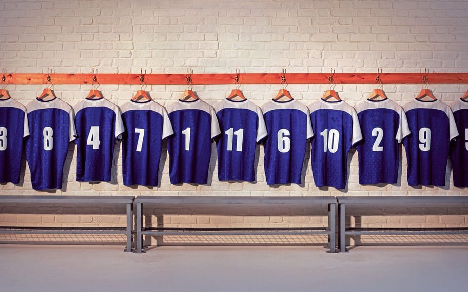 {"fr":"Maillots de sport alignés dans un vestiaire pour équipe en déplacement","en":"Sports jerseys in a locker room for a traveling team","es":"Camisetas deportivas en un vestuario para un equipo","de":"Sporttrikots in ein für ein reisendes Team"}