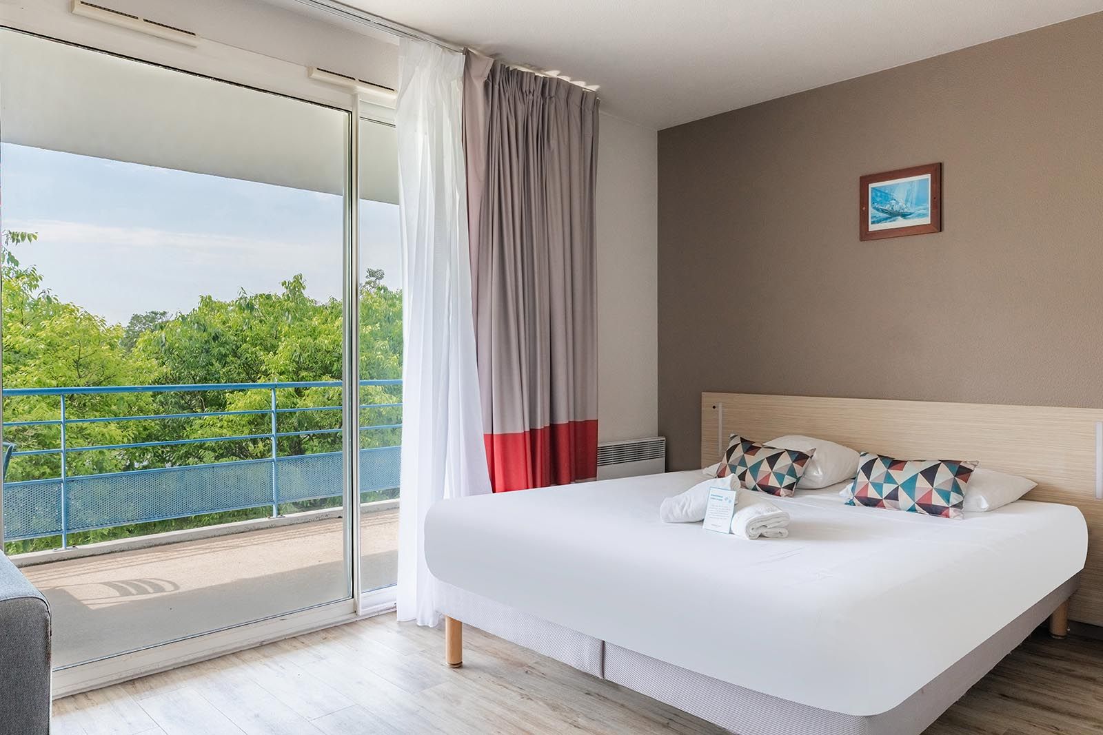 Appart’City La Rochelle mit Doppelbett und grünem Balkon