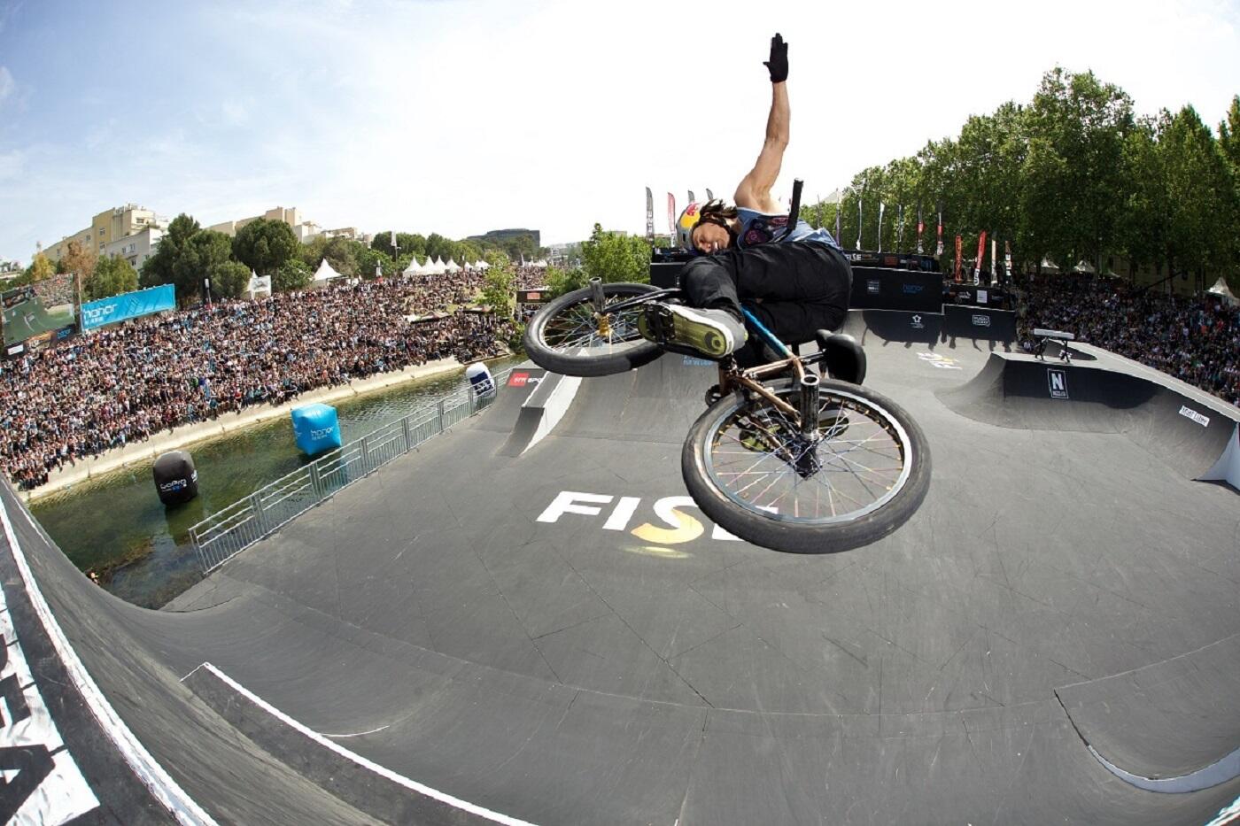 Atleta realizando una figura aérea de BMX en el FISE Montpellier, un evento imperdible para los aficionados a los deportes extremos, cerca de Appart'City.