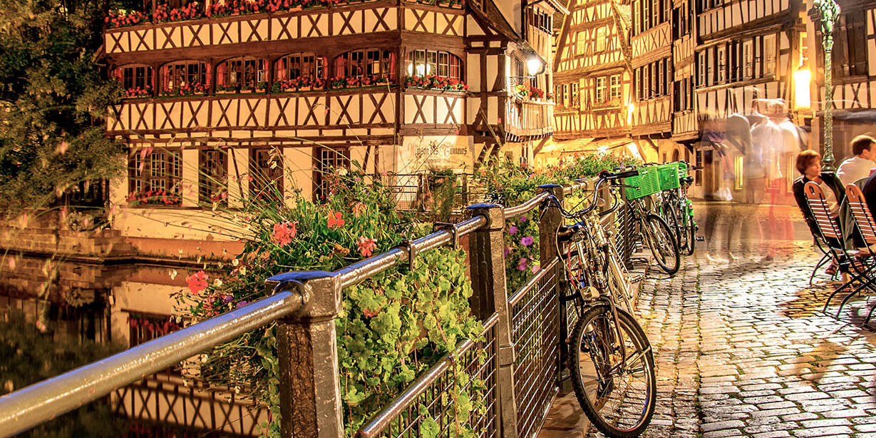 Picturesque night view of half-timbered houses and bicycles along the canal at the Foire Européenne de Strasbourg