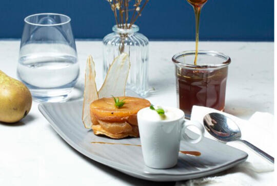 Caramelized pear dessert and gourmet coffee served at Bistrot City in the appart'hotel Geneva Airport Ferney-Voltaire, refined culinary experience.