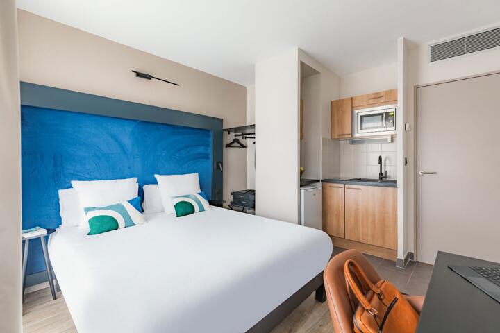 Modernes Zimmer mit großem Doppelbett und Kochnische im Aparthotel Paris Grande Bibliothèque.