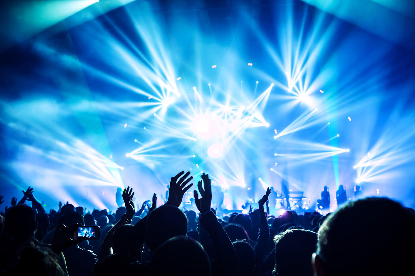 Ecstatic crowd at an I Love Techno Europe concert in Montpellier, vibrant and dynamic stage lights capturing the electrifying atmosphere of the event.