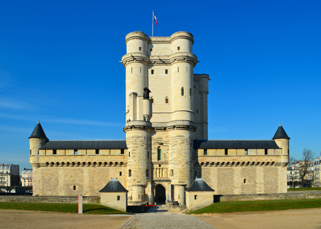 Das Schloss Vincennes unter einem klaren blauen Himmel, eine mittelalterliche Festung mit massiven Türmen und Befestigungsanlagen, Symbol für französische Geschichte und Militärarchitektur.