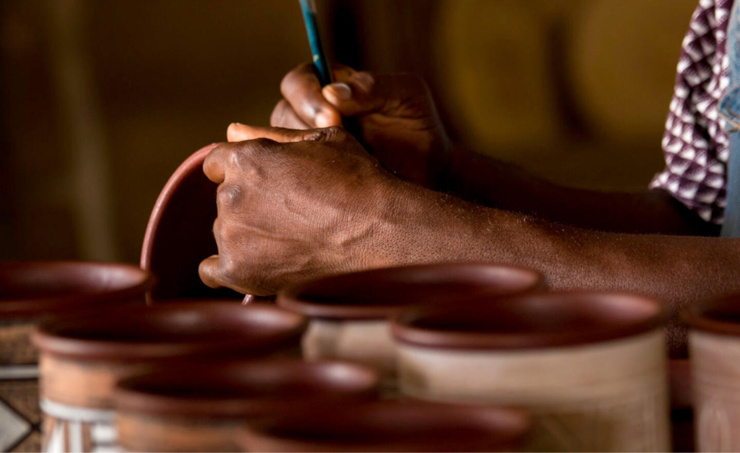 Artisan meticulously painting art pottery