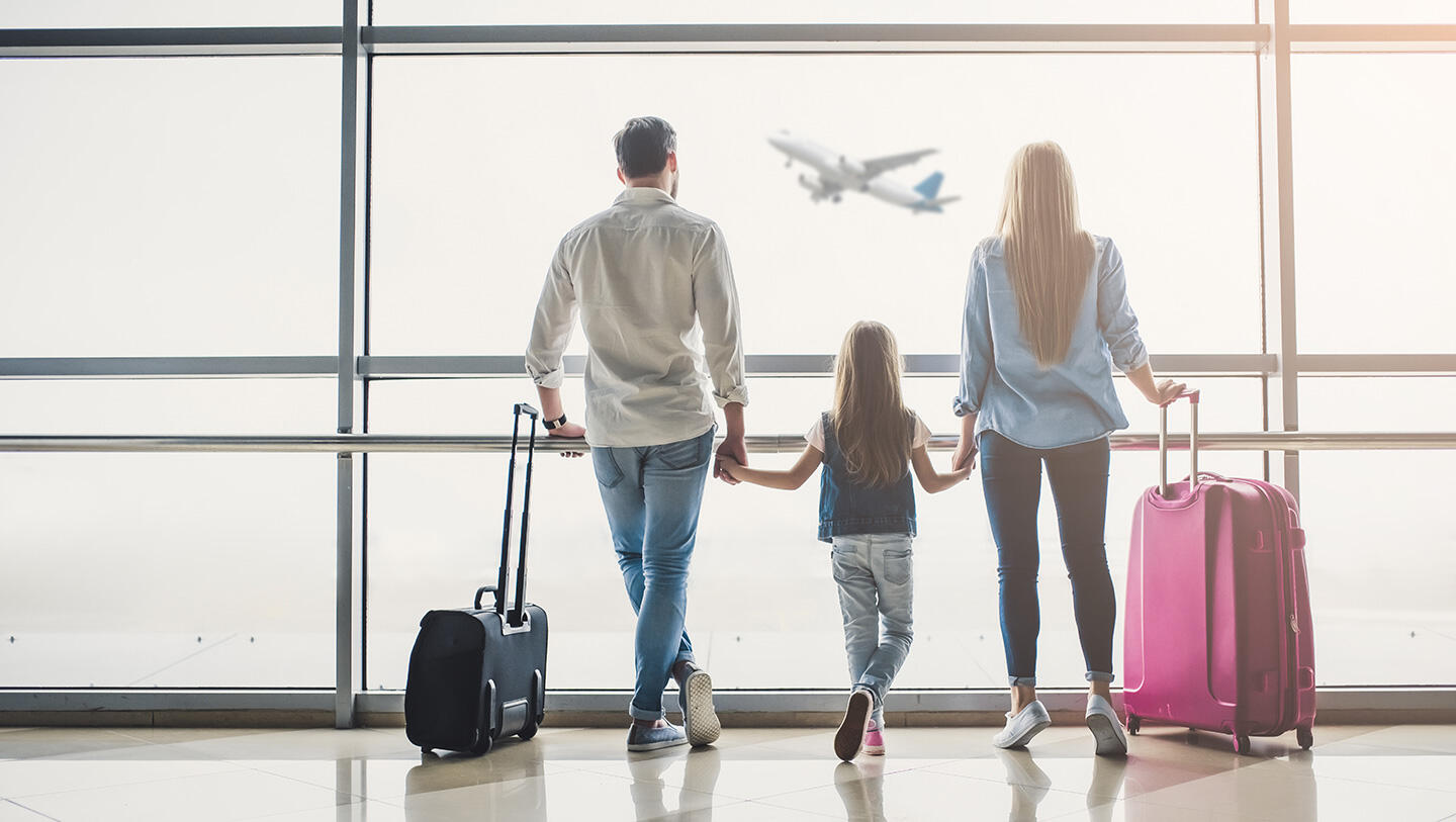 Familie beobachtet, wie ein Flugzeug am Flughafen Le Bourget abhebt, Hand in Hand mit Gepäck