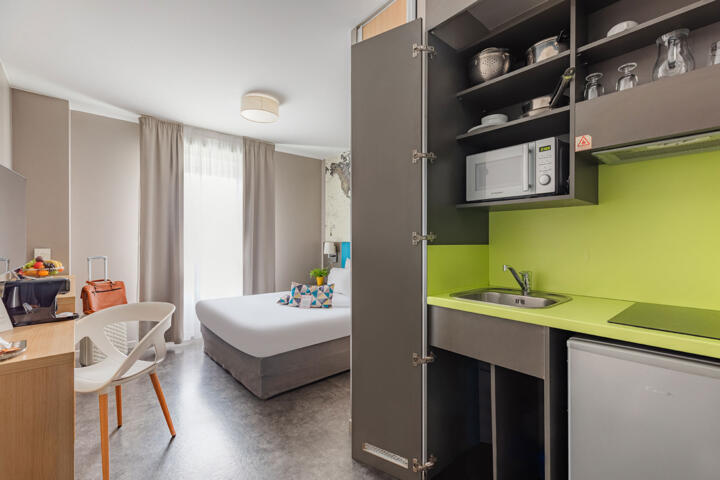 Modernes und helles Studio im Appart'Hôtel Appart'City Le Bourget mit voll ausgestatteter Küchenzeile, bequemem Doppelbett und zeitgemäßer Einrichtung.
