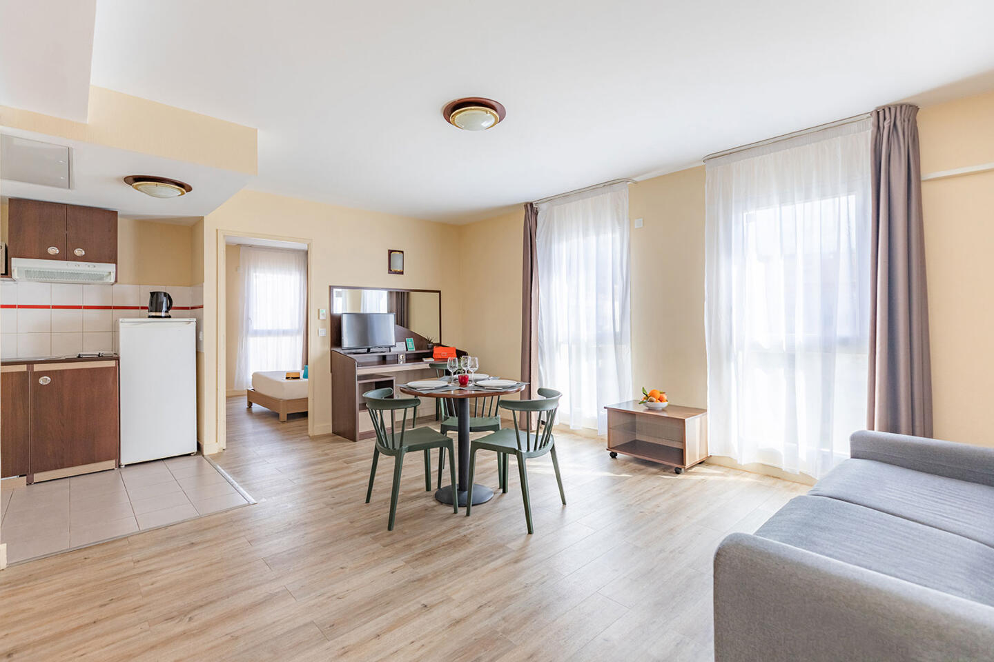 Modernes Aparthotel-Zimmer in Nizza bei Appart'City mit Doppelbett, Holzboden, Tageslicht und Reisegepäck